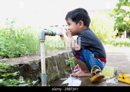 Boys playing in the fountain from the tap water Stock Photo