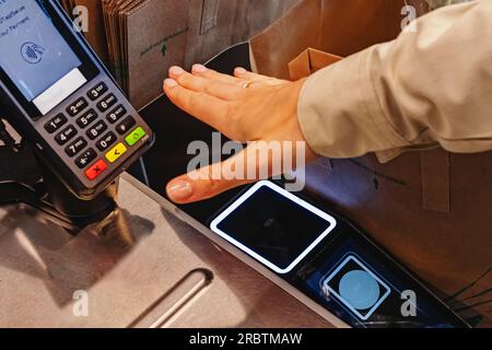 Close-up of female hand scanning her palm to pay with modern wireless payment technology Stock Photo