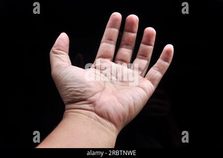 Asian man palms wide open fingers black background Stock Photo