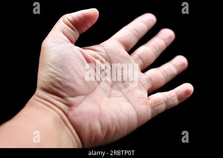 Asian man palms wide open fingers black background Stock Photo