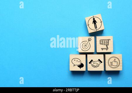 Professional buyer. Wooden cubes with different icons on light blue background, top view Stock Photo