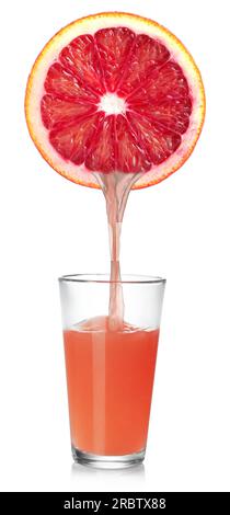 Pouring freshly squeezed juice from grapefruit into glass on white background Stock Photo