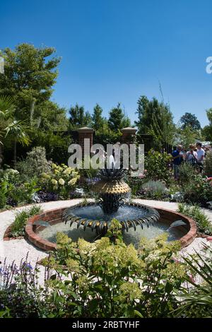 visitors admiring one of the show gardens at the RHS Hampton Court Flower Show in London Stock Photo