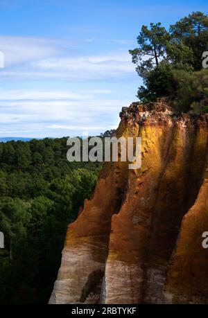 The beautiful rocks colored in shades of red, yellow and orange from the old ocher quarry in the city of Roussillon. Stock Photo