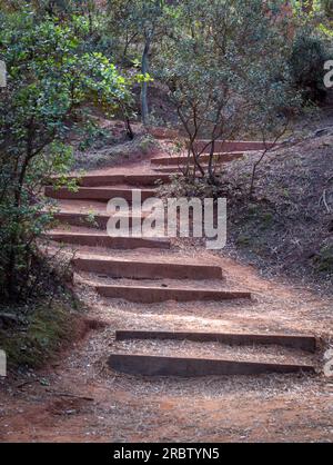 Image of the red earth and wooden stairs on the route of the ocher quarry in Roussillon. Stock Photo