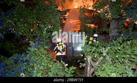 Glinde, Germany. 11th July, 2023. Firefighters extinguish a historic half-timbered house with thatched roof. The vacant building has burned down completely for still unknown reasons. Credit: Daniel Bockwoldt/dpa/Alamy Live News Stock Photo