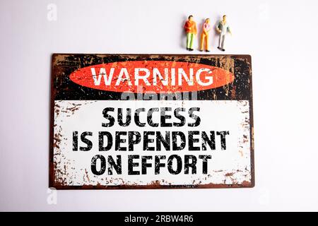 Success is Dependent on Effort. Warning sign with text on a white background. Stock Photo