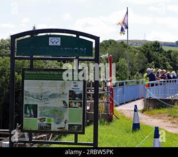 Beyond this information board on the top of Toddbrook dam a group of visitors are asking questions of Tom Greenwood during a public open day Stock Photo