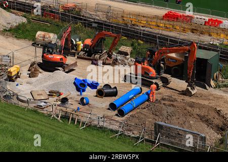 View from the top of Toddbrook dam down as big blue water control valves are waiting to be installed as part of the repairs to the dam Stock Photo