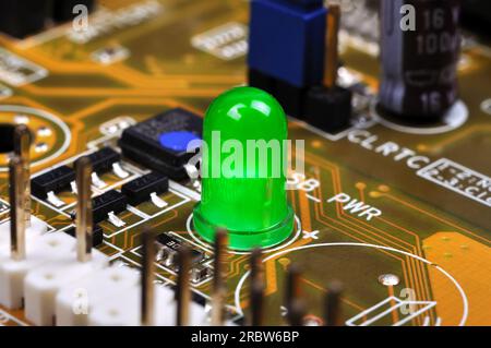 Green LED on yellow circuit board, close up Stock Photo