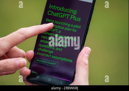 Finger using smartphone touchscreen to open and login to ChatGPT Plus, an AI service by OpenAI. Stock Photo