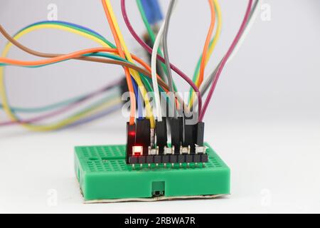 SMD LED or light emitting diodes connected to the breadboard using jumper wires and controlled by a microcontroller in the background Stock Photo