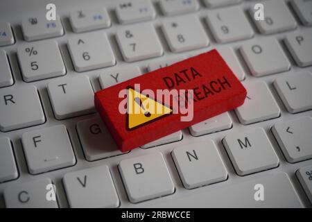 Close up image of computer keyboard and red wooden cube with text DATA BREACH. Internet, technology and network concept Stock Photo