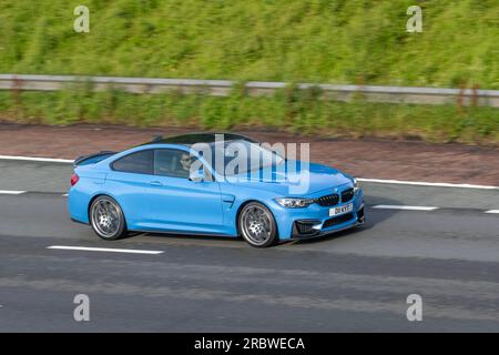 2019 BMW M4 Competition Package S-A M Twinpower Turbo DCT Auto Start/Stop Blue Car Coupe Petrol 2979 cc; travelling at speed on the M6 motorway in Greater Manchester, UK Stock Photo