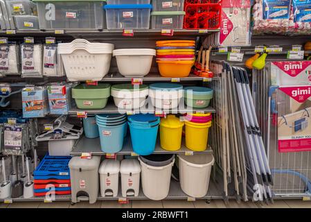 Italy - July 10, 2023: Multi-coloured buckets and basins, plastic boxes and plastic clotheslines and bathroom accessories on shelves for sale in Itali Stock Photo
