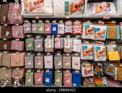 Italy - July 10, 2023: pillows and bedding sheet of various types and brands packaged for sale on the shelf of an Italian supermarket Stock Photo