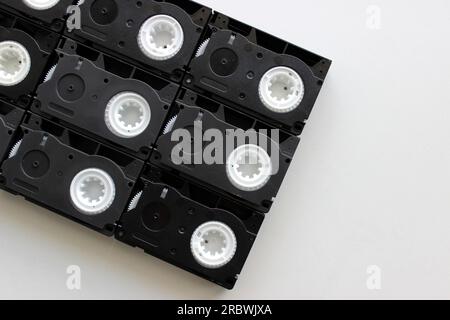 Huge video cassette laid out from small several VHS-С cassettes on white surface Stock Photo