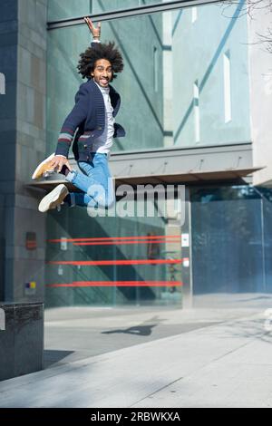 Happy young African American man jumping in the air. Stock Photo
