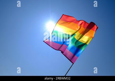 gay pride rainbow flag on blue sky background Stock Photo