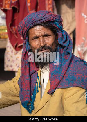 Uch Sharif, Punjab, Pakistan - 11 12 2019 : Vertical portrait of middle aged rural punjabi man wearing traditional red and blue head scarf Stock Photo