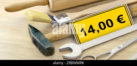 Werkzeug und gelbes Schild mit 14,00 Euro Mindestlohn in Deutschland Stock Photo