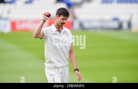 Hove UK 11th July 2023 - Derbyshire bowler George Scrimshaw holds up the match ball after taking five wickets against Sussex in the first innings during day two of the LV= Insurance County Championship cricket match at the 1st Central County Ground in Hove : Credit Simon Dack /TPI/ Alamy Live News Stock Photo