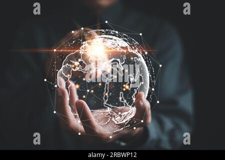A businessman's hand holds a globe, illustrating seamless connectivity and data flow across global network Stock Photo