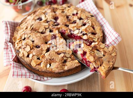 Cherry pie with almonds on wooden table. Baked with fresh sour cherries Stock Photo