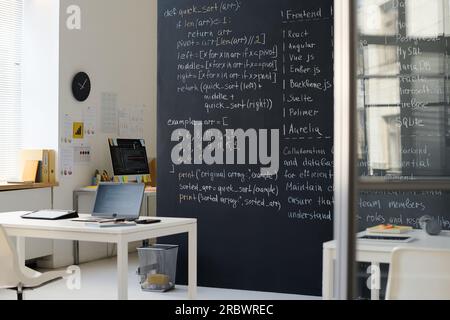 Modern empty IT class with formulas on blackboard and codes on computers Stock Photo