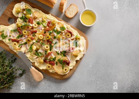 Homemade trendy Butterboard with onion, garlic, herbs, crispy baguette on gray background. Copy space. View from above. Stock Photo