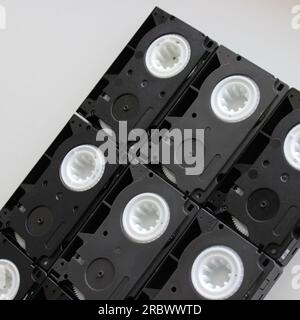 Black block made by rows of old small tape video cassettes on white surface Stock Photo