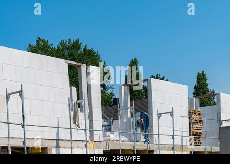 Walls of a building under construction from white blocks under a clear blue sky. Stock Photo