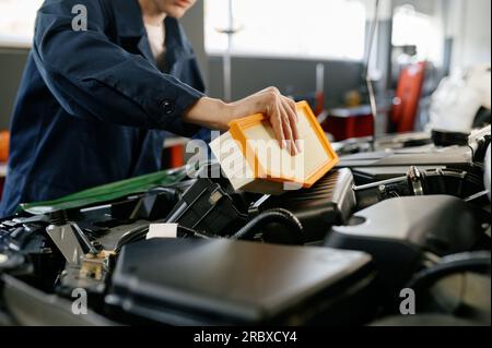 Engine air filter replacement concept, closeup shot of auto mechanic at work Stock Photo