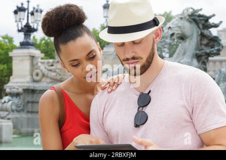 portrait of happy couple using digital tablet in city Stock Photo