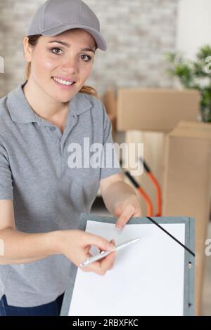 woman receiving parcels from delivery service courier indoors Stock Photo