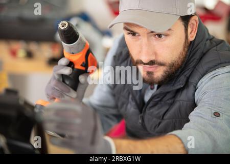 close view of tradesman using cordless drill in the workshop Stock Photo