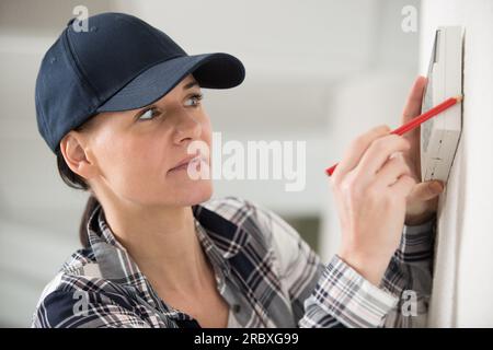 female technician installing security system Stock Photo