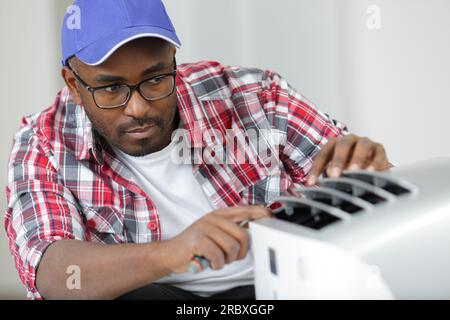 young male contractor repairing toaster at workshop Stock Photo
