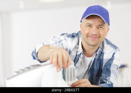 mature male technician repairing appliance Stock Photo