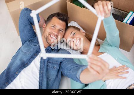happy couple looks through a house build with a ruler Stock Photo