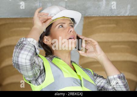 engineer woman with safety hard hat talking on phone Stock Photo