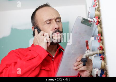 technician reading the water meter to check consumption Stock Photo