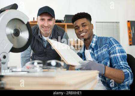 student and teacher in carpentry class using circular saw Stock Photo