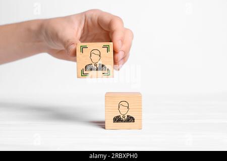 Professional buyer. Woman holding wooden cube with human icon on white background, closeup Stock Photo