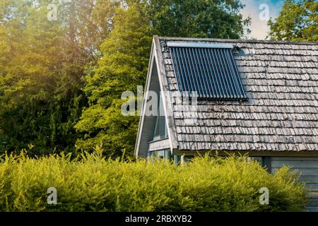 A solar thermal panel, evacuated tube, OPC 15, mounted on the wall of a ...