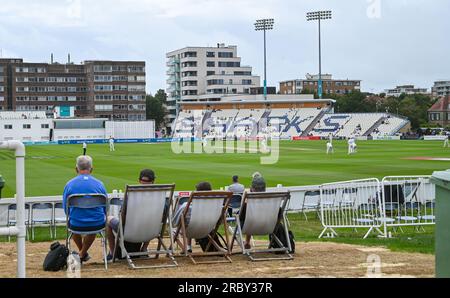 Hove UK 11th July 2023 -  Spectators watch Sussex take on Derbyshire in gloomy conditionsduring day two of the LV= Insurance County Championship cricket match at the 1st Central County Ground in Hove : Credit Simon Dack /TPI/ Alamy Live News Stock Photo