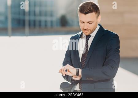 Businessman in suit posing in studio background closing his jack Stock  Photo by ©feedough 98559212