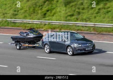 2014 Black Vauxhall Insignia C-Trytour Nav4x4 Bt A Cdti 195 Biturbo 4WD Activeselect Auto Grey Car Estate Diesel 1956 cc towing Seadoo Jetski travelling at speed on the M6 motorway in Greater Manchester, UK Stock Photo