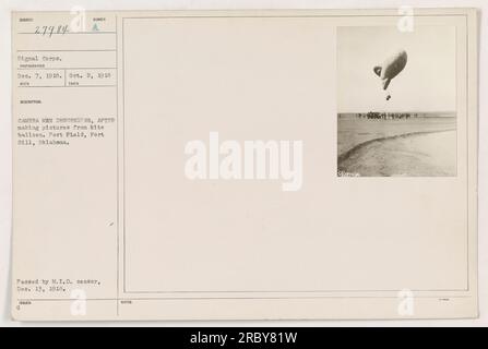Camera men descending from a kite balloon after capturing pictures. Photograph taken on October 2, 1918, at Post Field in Fort Sill, Oklahoma. This image is numbered 27984 and belongs to the Signal Corps. It was taken by a photographer on December 7, 1918 and approved by the MID censor on December 13, 1918. Stock Photo