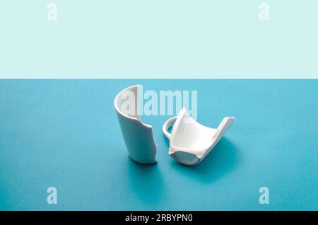Cup broken in half, symbolizing the break and the end of something that was once whole. Stock Photo